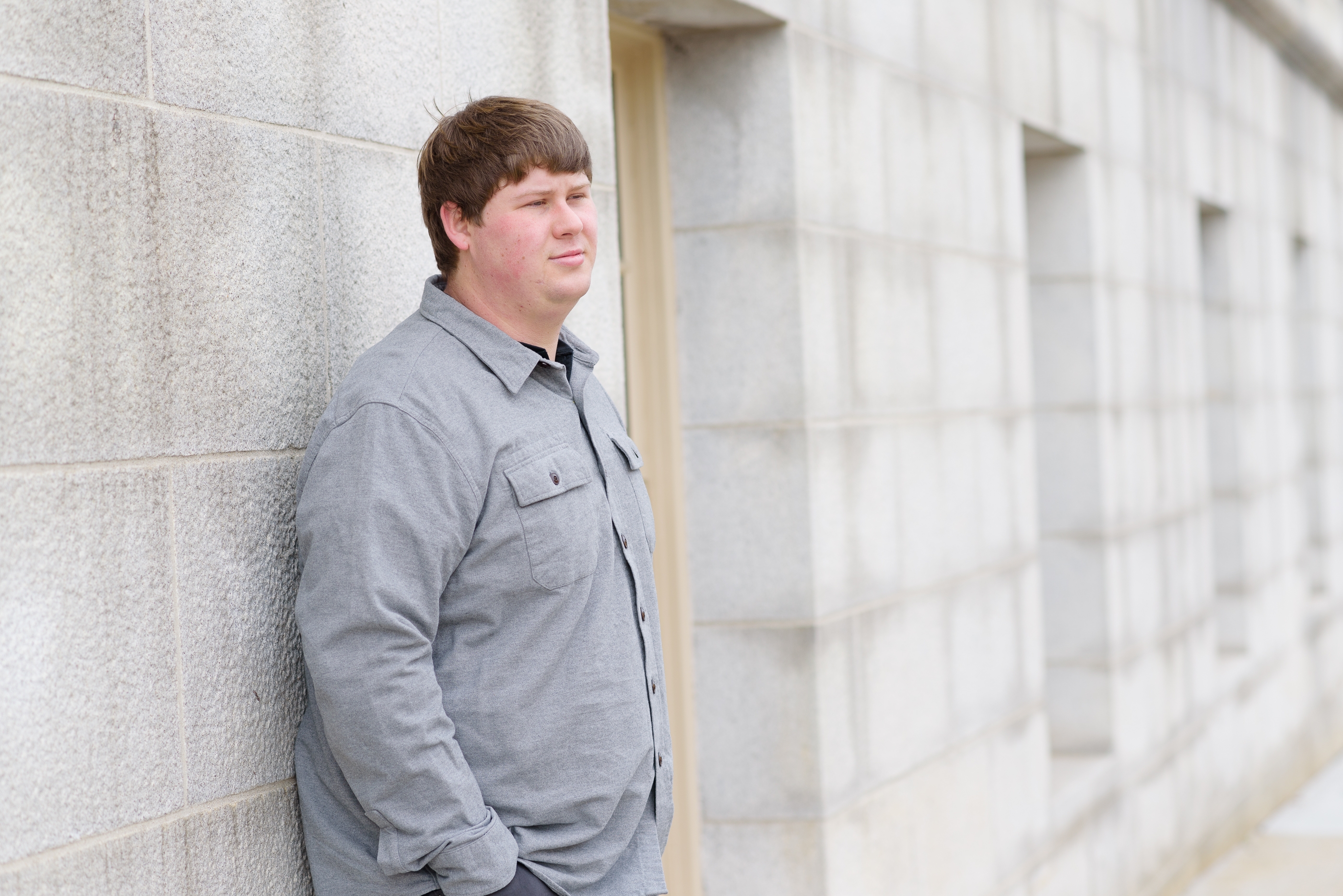 Comedian, Colby Bradshaw, leaning on a wall.
