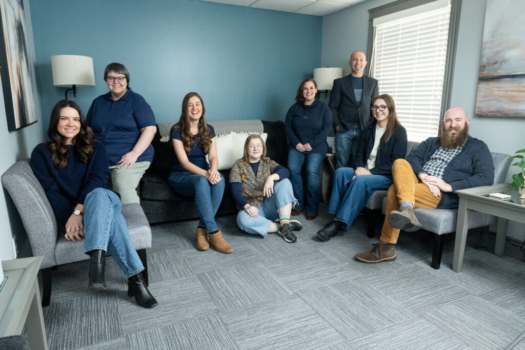 Group photo of the Ellie Mental Health Falmouth team in a casual, candid pose inside the clinic