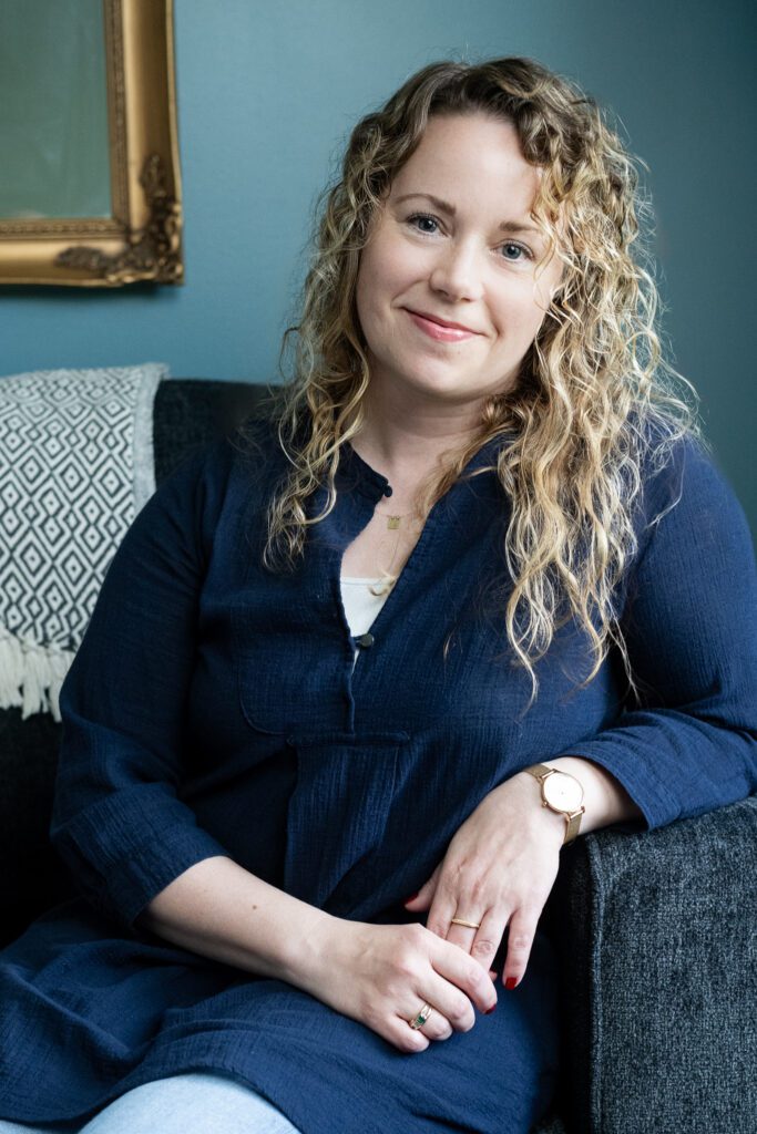 A therapist at Ellie Mental Health Falmouth in a relaxed, candid headshot inside the clinic